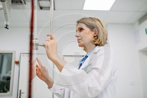 Doctor operating dynamic X-ray scan using tilting fluoroscopy unit