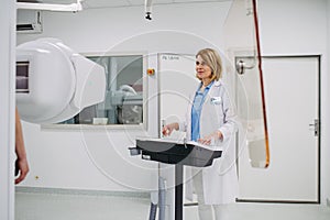 Doctor operating dynamic X-ray scan using tilting fluoroscopy unit