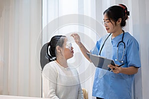 A doctor or ophthalmologist is checking a patient's eye in the examination room at the hospital