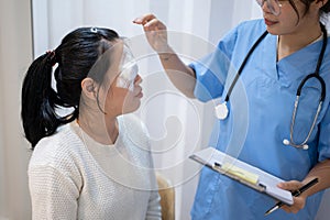 A doctor or ophthalmologist is checking a patient's eye in the examination room at the hospital