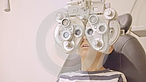 Doctor optometrist checks little boy's eyesight. Child in ophthalmologist room.