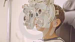 Doctor optometrist checks little boy's eyesight. Child in ophthalmologist room.