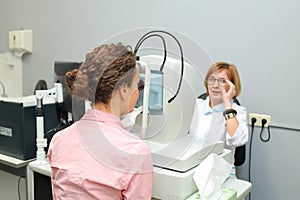 Doctor optometrist looking patients eye with an