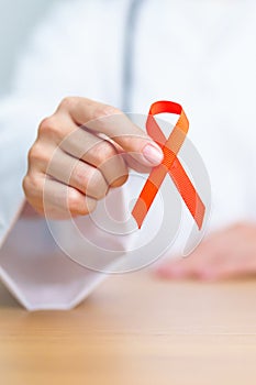 Doctor with Orange Ribbon for Leukemia, Kidney cancer day, world Multiple Sclerosis, CRPS, Self Injury Awareness month. Healthcare