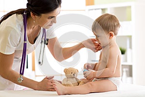 Doctor paediatrician checking boy`s neck