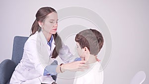 Doctor is palpating lymph node on the neck of 7 years old boy, medical checkup