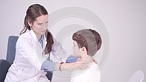 Doctor is palpating lymph node on the neck of 7 years old boy, medical checkup