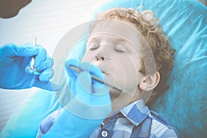 Doctor and patient child. Boy having his teeth examined with dentist. Medicine, health care and stomatology concept