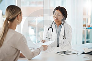 Doctor and patient discuss paperwork during medical consultation in a hospital. Healthcare professional, GP or physician