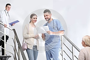 Doctor and patient discussing diagnosis on stairs in hospital