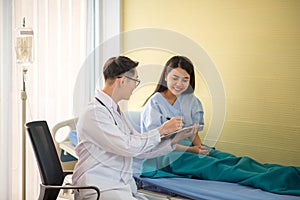 Doctor and patient discussing something while checking health in the bed at hospital