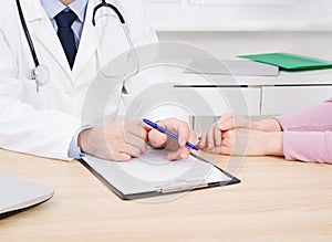 Doctor and patient are discussing something, just hands at the table, medical insurance