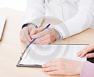 Doctor and patient are discussing something, just hands at the table, medical insurance.