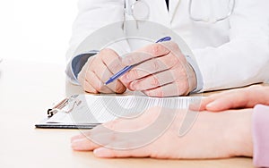 Doctor and patient are discussing something, just hands at the table, medical insurance.