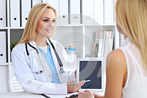 Doctor and patient discussing something while physician pointing into touch pad computer