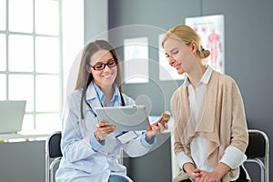 Doctor and patient discussing something while sitting at the table . Medicine and health care concept