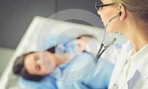 Doctor and patient discussing something while sitting at the table . Medicine and health care concept