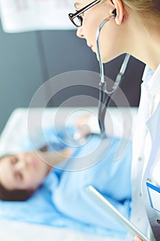 Doctor and patient discussing something while sitting at the table . Medicine and health care concept