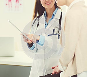 Doctor and patient discussing something while sitting at the table . Medicine and health care concept