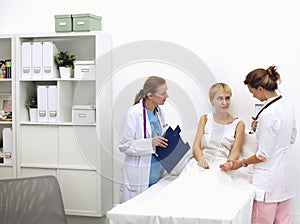 Doctor and patient discussing something while sitting at the table . Medicine and health care concept