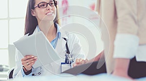 Doctor and patient discussing something while sitting at the table . Medicine and health care concept