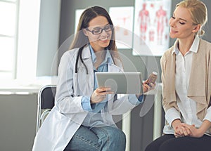 Doctor and patient discussing something while sitting at the table . Medicine and health care concept