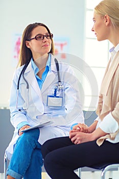 Doctor and patient discussing something while sitting at the table . Medicine and health care concept