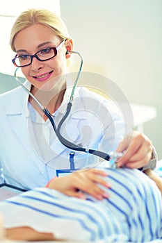 Doctor and patient discussing something while sitting at the table . Medicine and health care concept