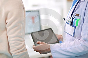 Doctor and patient discussing something while sitting at the table . Medicine and health care concept. Doctor and