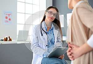 Doctor and patient discussing something while sitting at the table . Medicine and health care concept. Doctor and