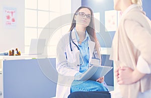 Doctor and patient discussing something while sitting at the table . Medicine and health care concept. Doctor and