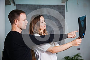 Doctor and patient examine head roentgen at clinic