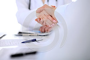 Doctor and patient handshaking. Hands close-up