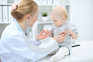 Doctor and patient in hospital. Little girl is being examined by pediatrician with stethoscope. Medicine and health care