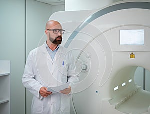 Doctor with a patient medical card near MRI scanner in a hospital