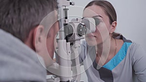 Doctor and patient in ophthalmology clinic. Male patient checking vision with special eye equipment. Optometry concept
