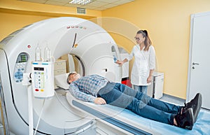 Doctor and patient in the room of computed tomography at hospital.