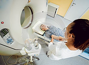 Doctor and patient in the room of computed tomography at hospital.