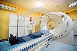 Doctor and patient in the room of computed tomography at hospital.