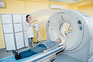 Doctor and patient in the room of computed tomography at hospital.