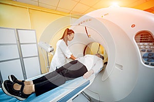 Doctor and patient in the room of computed tomography at hospital.