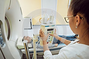 Doctor and patient in the room of computed tomography at hospital.