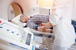 Doctor and patient in the room of computed tomography at hospital.