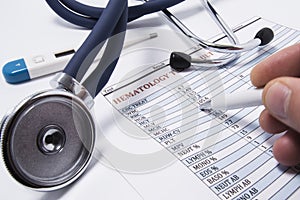 Doctor during the patient`s visit, holding a pen in the hand, showing patient the possible pathological changes in the blood analy