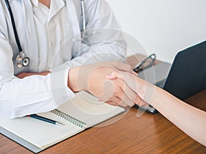 Doctor and Patient are shaking hand in the hospital. Health care and Medical Concept