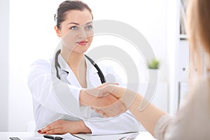 Doctor and patient shaking hands to each other. Healthcare, medicine and trusting concept