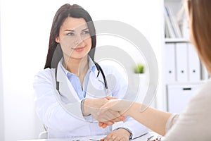 Doctor and patient shaking hands to each other. Healthcare, medicine and trusting concept