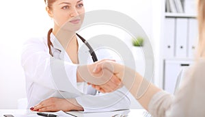 Doctor and patient shaking hands to each other. Healthcare, medicine and trusting concept