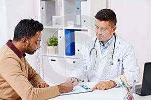 Doctor and patient signing document at clinic