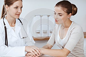 Doctor and patient are sitting and discussing health examination results in clinic office. Health care, medicine and